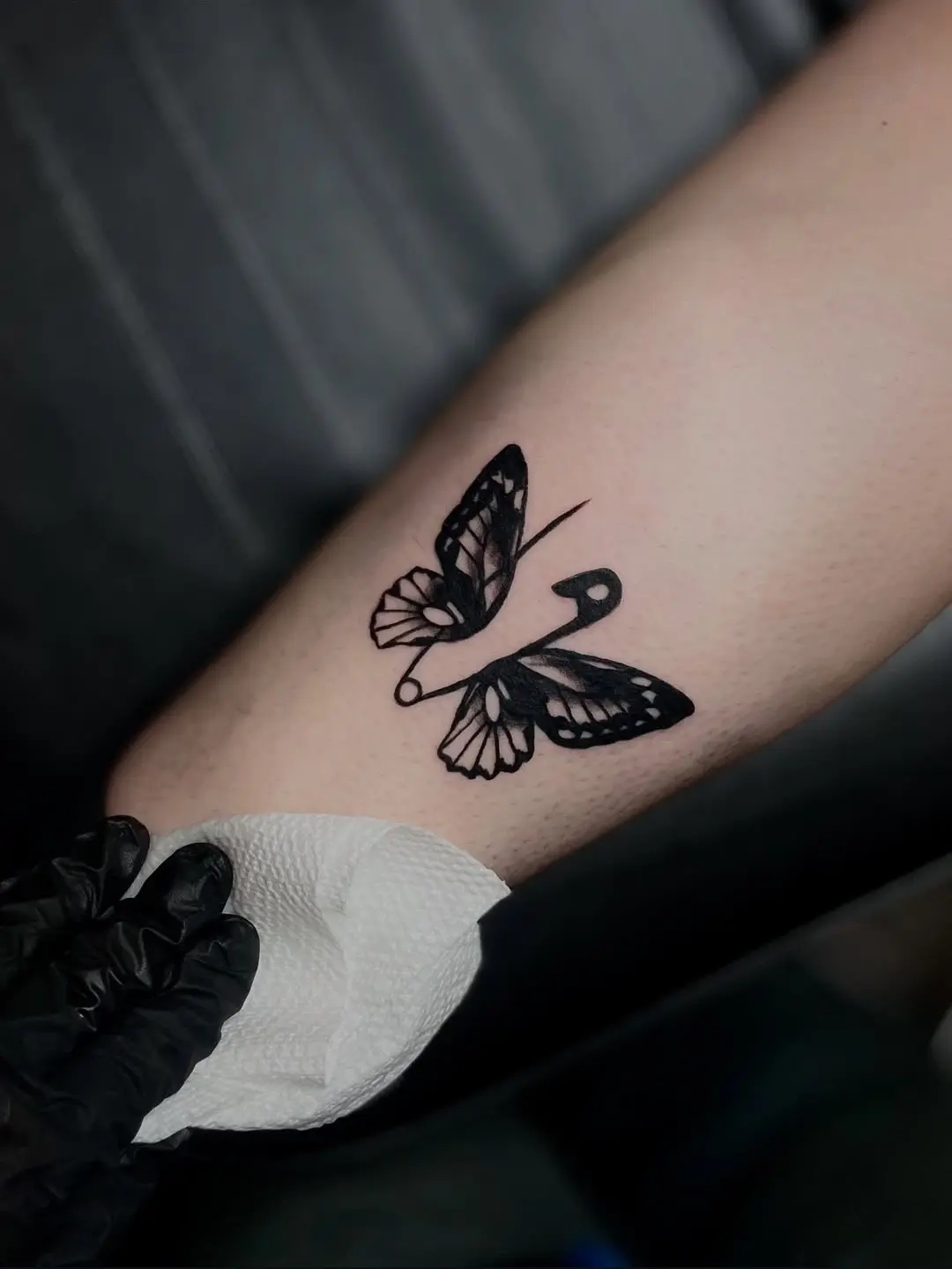 Minimalist butterfly and safety pin tattoo on forearm, Tainted Flesh Body Art North Wilmington DE