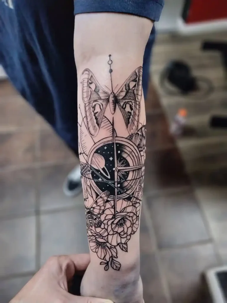 Fine line tattoo on forearm featuring a moth, compass, planets, and florals