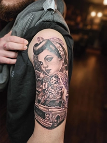 Colorful watercolor tattoo on forearm blending soft pink and blue tones, Wilmington DE tattoo studio work