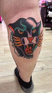 Colorful custom tattoo on upper arm featuring bright saturated pigment work