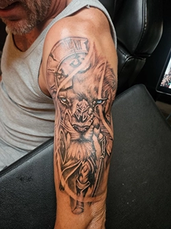 Detailed color tattoo on upper arm featuring bold custom shading work