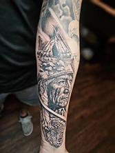 Compact black and grey tattoo on hand with fine detailed linework