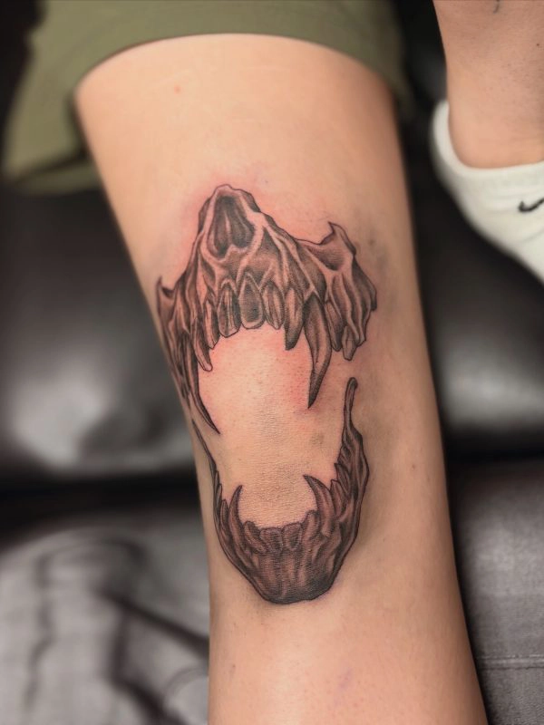 Black and grey animal skull tattoo on the upper arm
