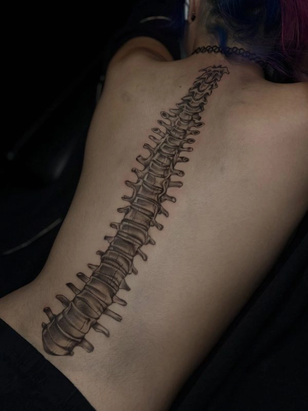 Black and grey spine and dragon tattoo running down the back