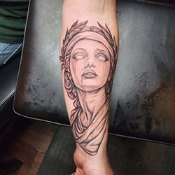 Black and grey classical portrait tattoo of a woman's face on the forearm