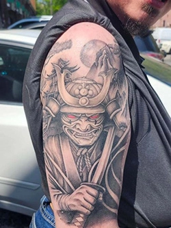 Black and grey samurai warrior tattoo on the upper arm