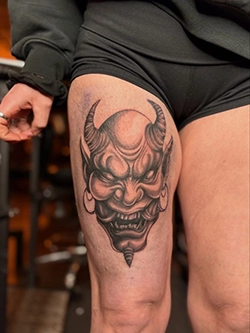 Black and grey hannya demon mask tattoo on the thigh